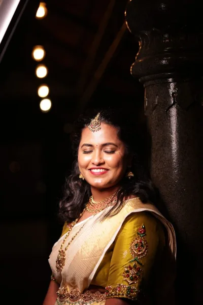 Kerala bride in a gold embroidered blouse in low evening light
