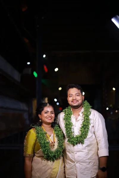 Bride and groom wearing ceremonial garlands at night