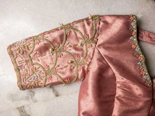 Hand-embroidered sleeve of a pink silk blouse