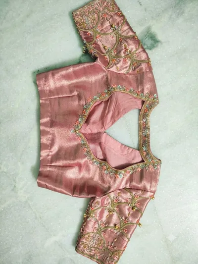 Embroidered back neckline of a pink silk blouse