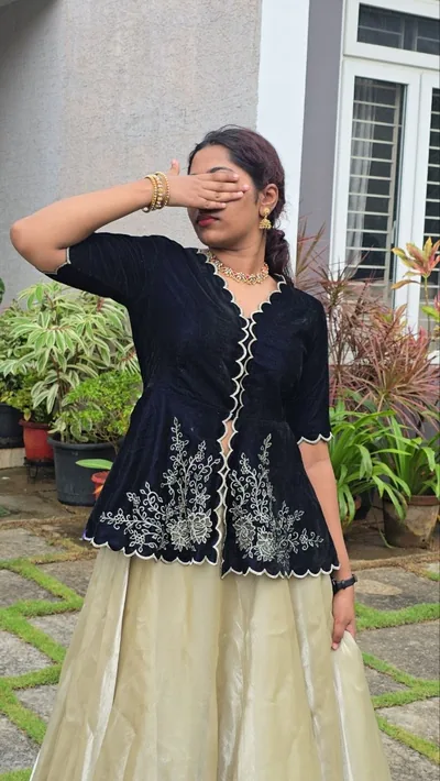 Black velvet peplum with scalloped embroidery and an ivory skirt