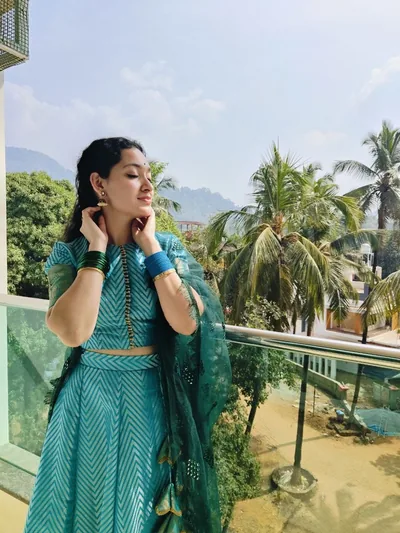Teal chevron lehenga on a balcony among palms